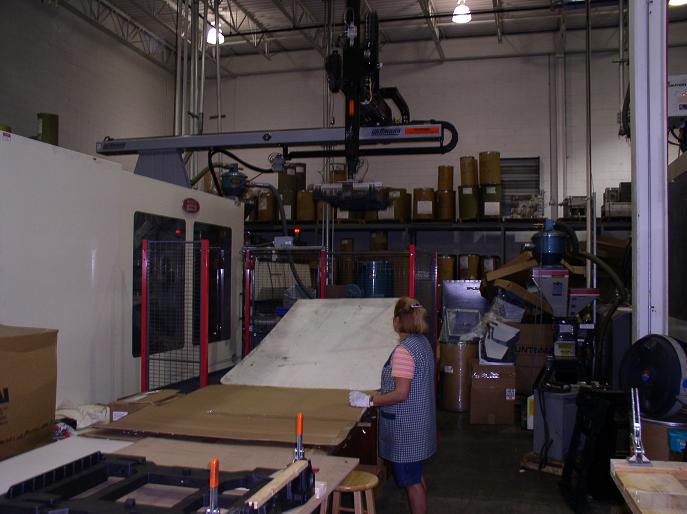 Robotic crane lifting HTS frame to production worker